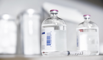 Pharmaceutical bottles on counter next to syringe