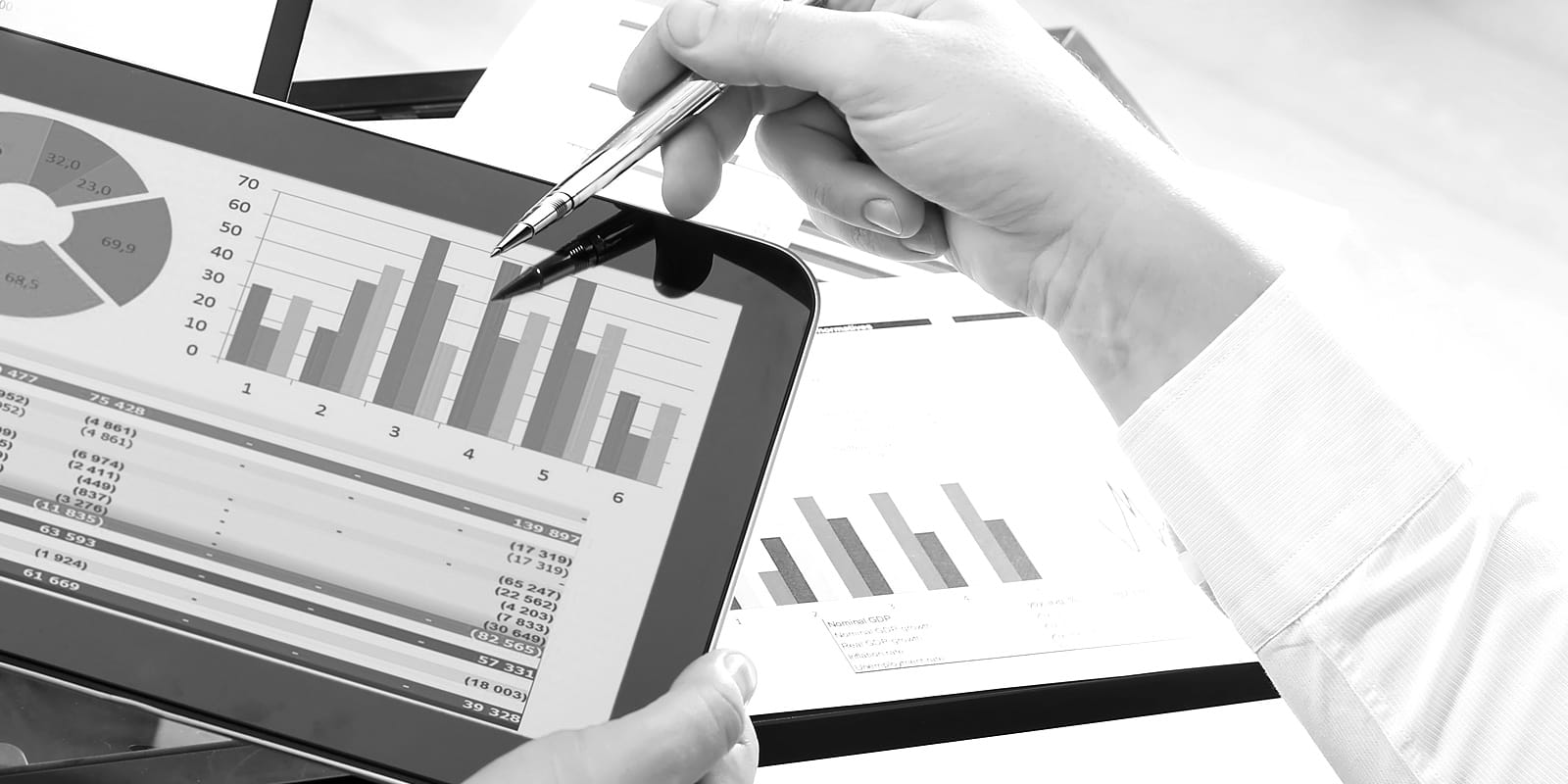Hand using a pen to point at performance data on a tablet