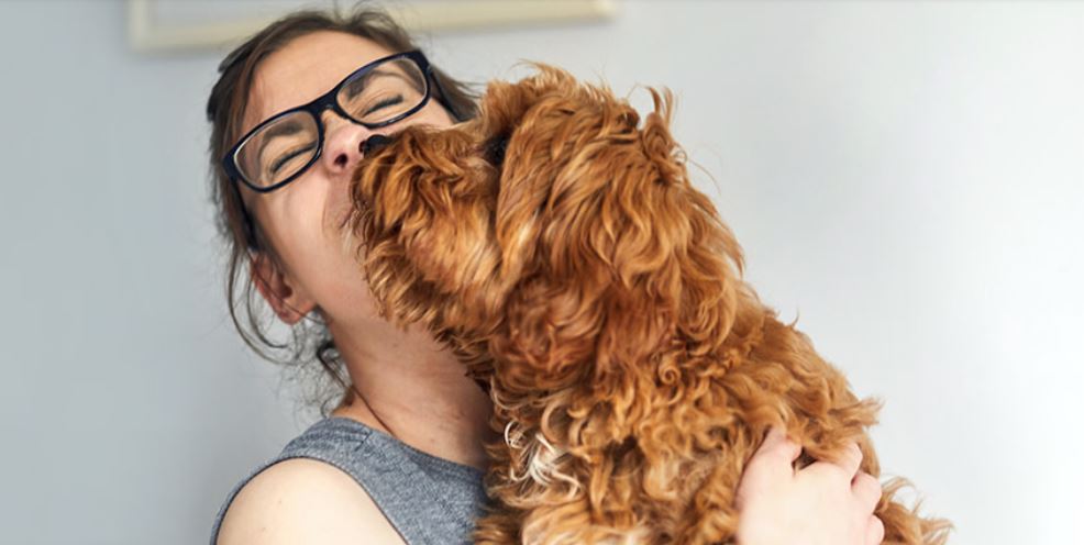 Woman holding dog, getting kisses