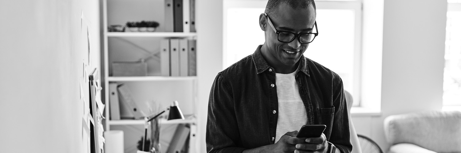 Man sending a text message from home